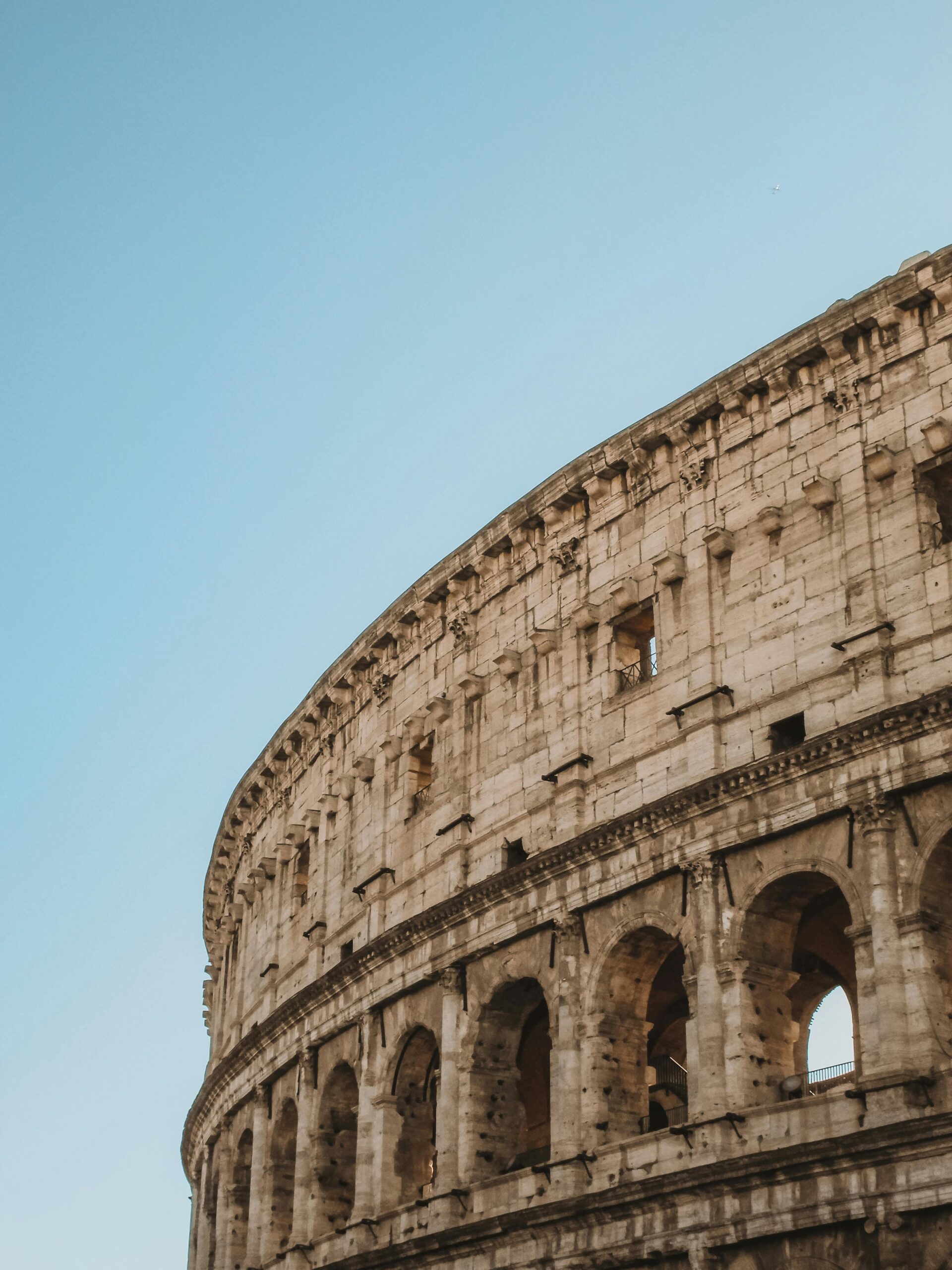 A stunning view of the iconic Colosseum in Rome with a clear blue sky.